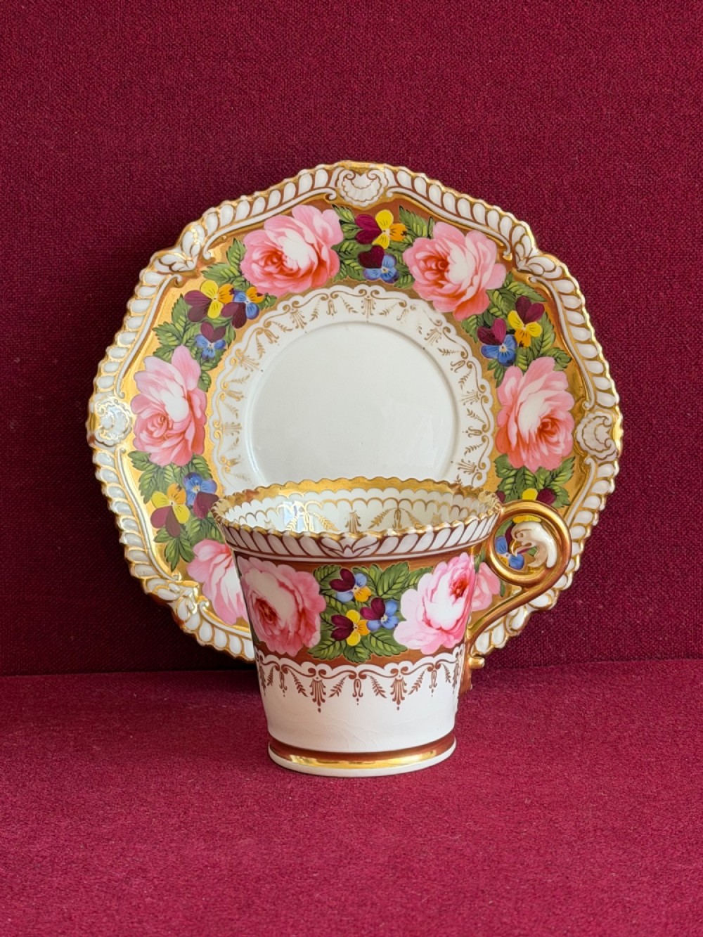 An antique Regency Chamberlain Worcester porcelain trio featuring hand-painted pink roses, pansies, rich gilded borders, and eagle-head handle terminals. View II