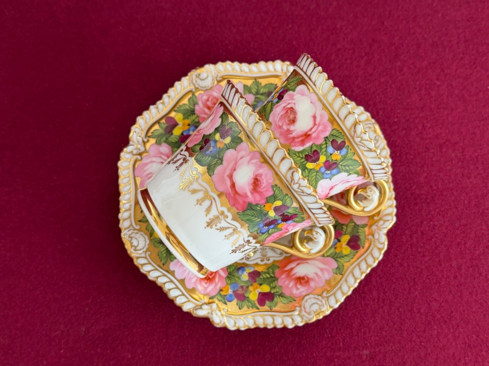 An antique Regency Chamberlain Worcester porcelain trio featuring hand-painted pink roses, pansies, rich gilded borders, and eagle-head handle terminals. View V