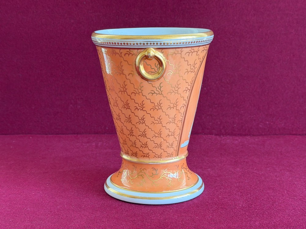 A Regency Flight & Barr Worcester porcelain jardiniere featuring an orange ground, gilt seaweed patterning, and a classical female figure painted in grisaille inside a oval frame. View IV