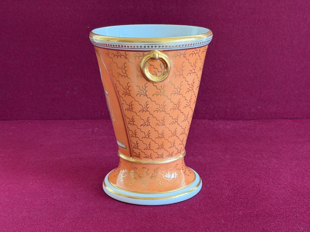 A Regency Flight & Barr Worcester porcelain jardiniere featuring an orange ground, gilt seaweed patterning, and a classical female figure painted in grisaille inside a oval frame. View VI