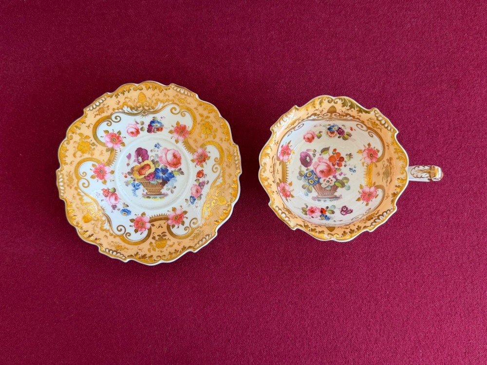 A Regency period H and R Daniel porcelain trio comprising a teacup, coffee cup, and saucer decorated with gilded scrolling borders and hand-painted floral sprigs. View II