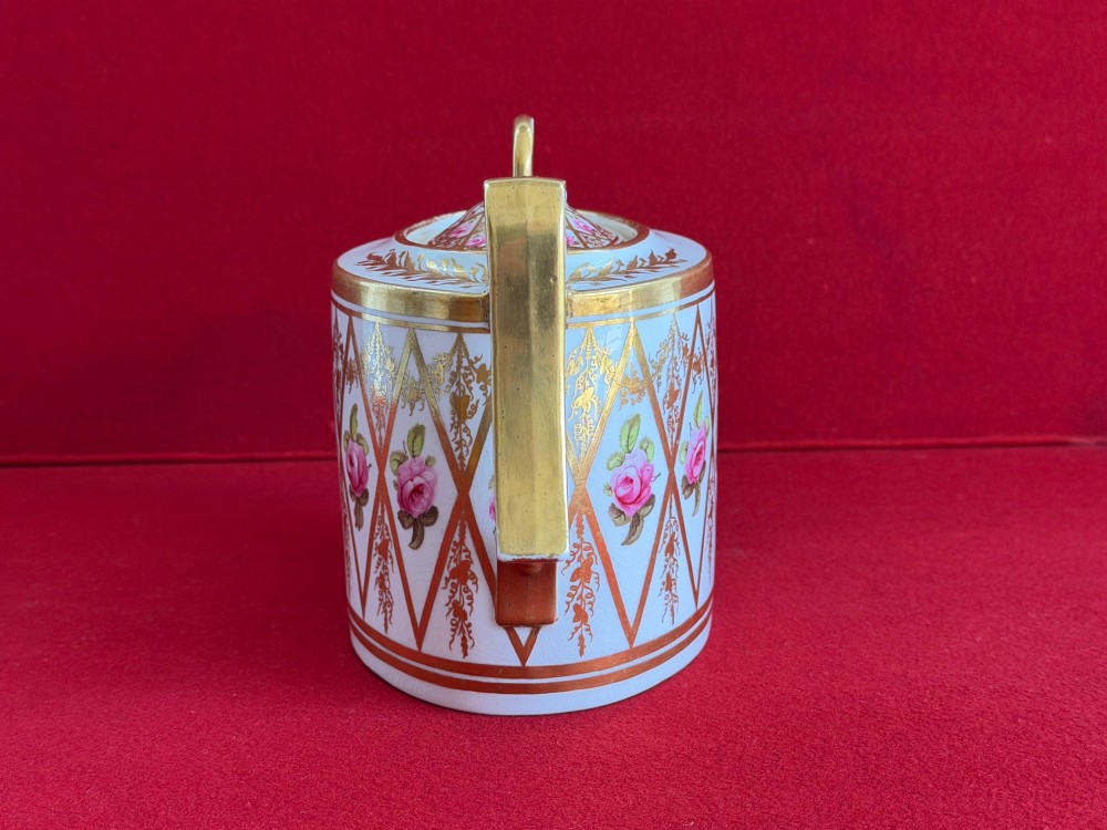 An antique oval white porcelain teapot decorated with hand-painted pink roses inside gilded diamond lozenges and gold rim details. View III