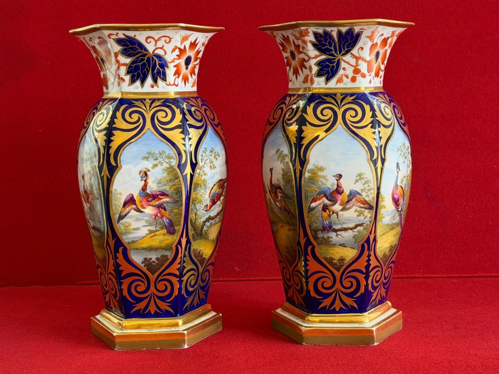 A pair of Regency period Flight, Barr & Barr Worcester porcelain vases featuring cobalt blue ground, heavy gold scrollwork, and painted exotic bird reserves.
