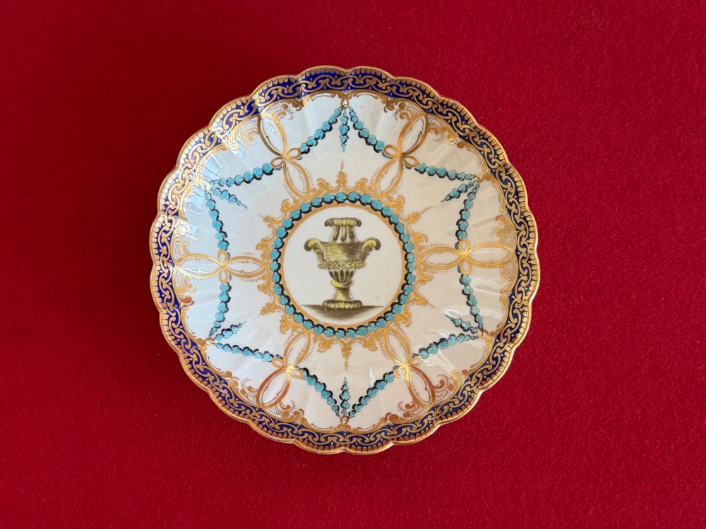 An 18th-century Worcester porcelain trio comprising a teacup, coffee cup, and saucer decorated with fluted moulding, blue swags, Classical urn motifs, and gold leaf gilding. View II