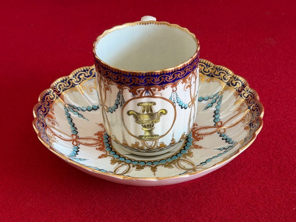 An 18th-century Worcester porcelain trio comprising a teacup, coffee cup, and saucer decorated with fluted moulding, blue swags, Classical urn motifs, and gold leaf gilding. View III