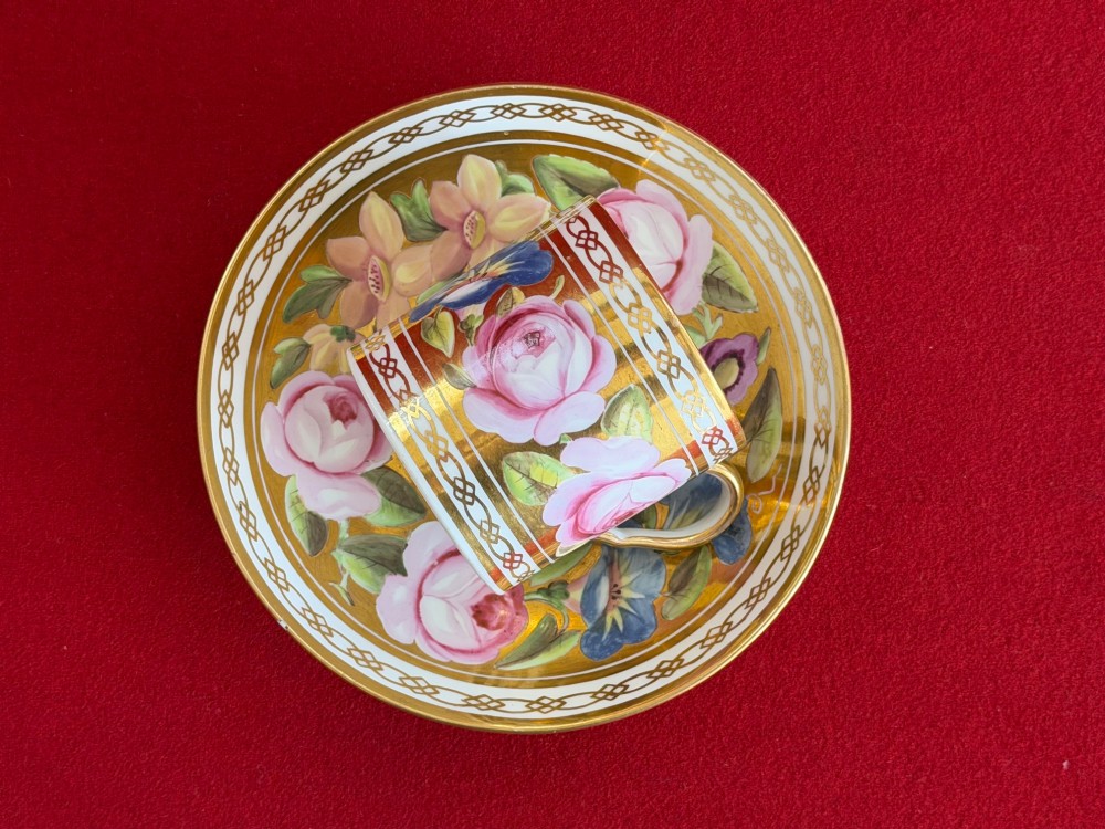 A Regency John Rose Coalport porcelain trio comprising a teacup, coffee can, and matching saucer featuring hand-painted pink roses on a gold ground. View III