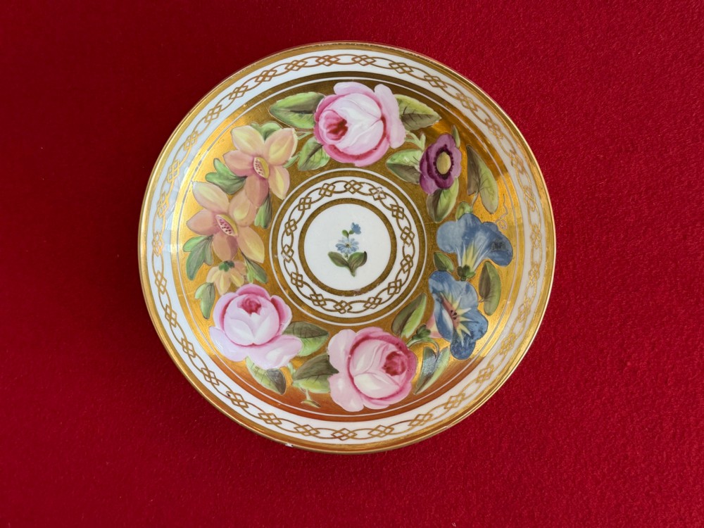 A Regency John Rose Coalport porcelain trio comprising a teacup, coffee can, and matching saucer featuring hand-painted pink roses on a gold ground. View IX