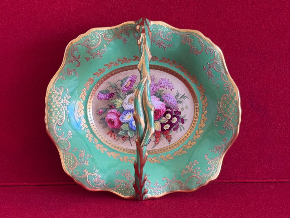 An antique green porcelain basket featuring a central hand-painted floral bouquet, gilt scrolling filigree, and a gilded branch handle. View II