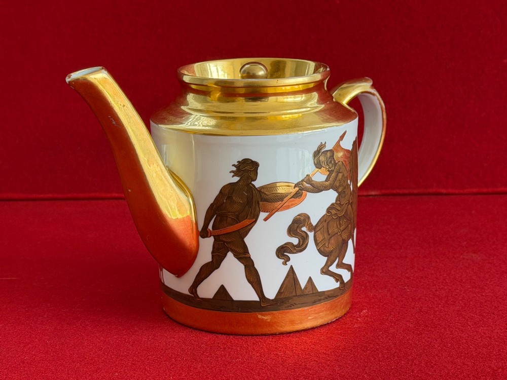 A Regency cylindrical porcelain teapot featuring a gilded spout and collar alongside hand-painted classical figures on a white ground. View II