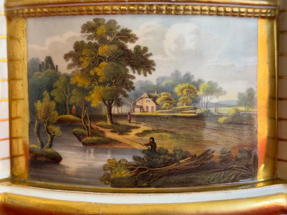 An English porcelain spill vase in the form of a castle with gilded turrets, crenellated rims, and a central painted landscape panel. View II