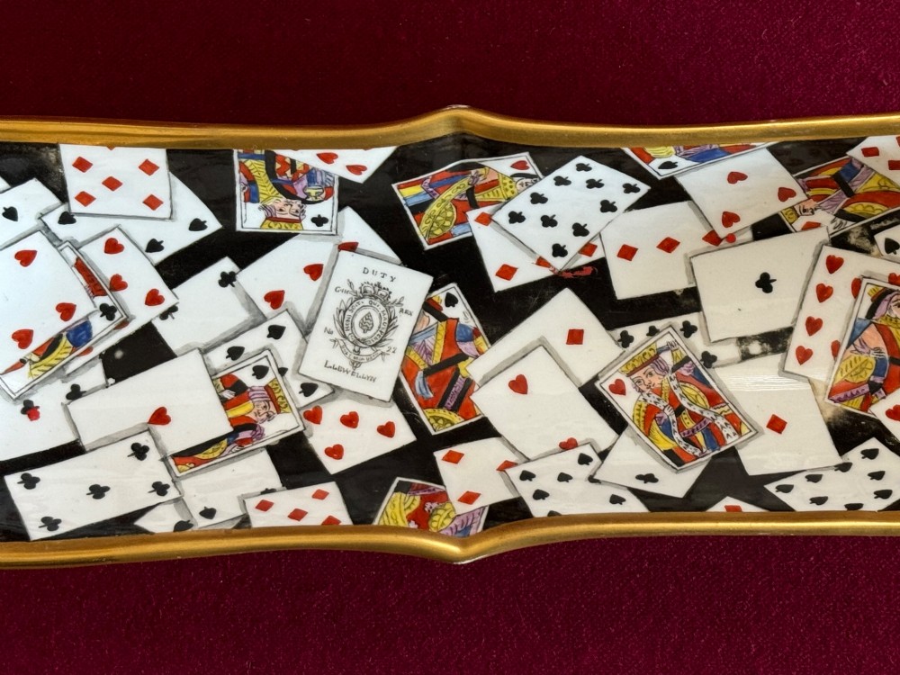 A Regency porcelain pen tray featuring a hand-painted playing card motif on a black background, framed by twin gilded handles. View III