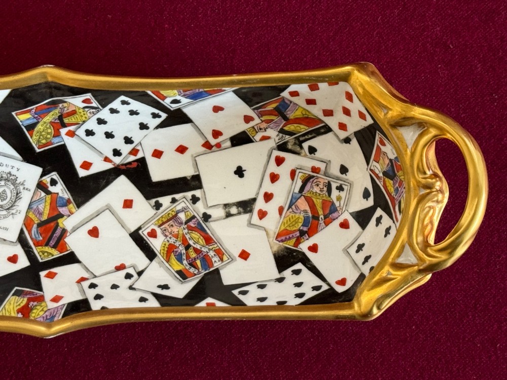 A Regency porcelain pen tray featuring a hand-painted playing card motif on a black background, framed by twin gilded handles. View IV