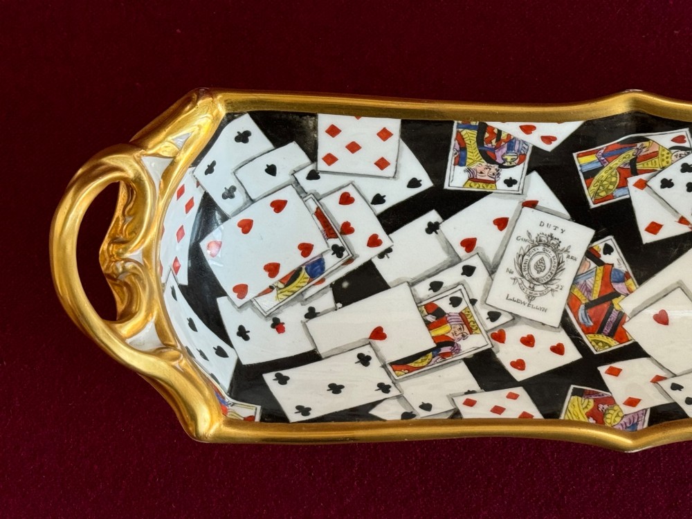 A Regency porcelain pen tray featuring a hand-painted playing card motif on a black background, framed by twin gilded handles. View V