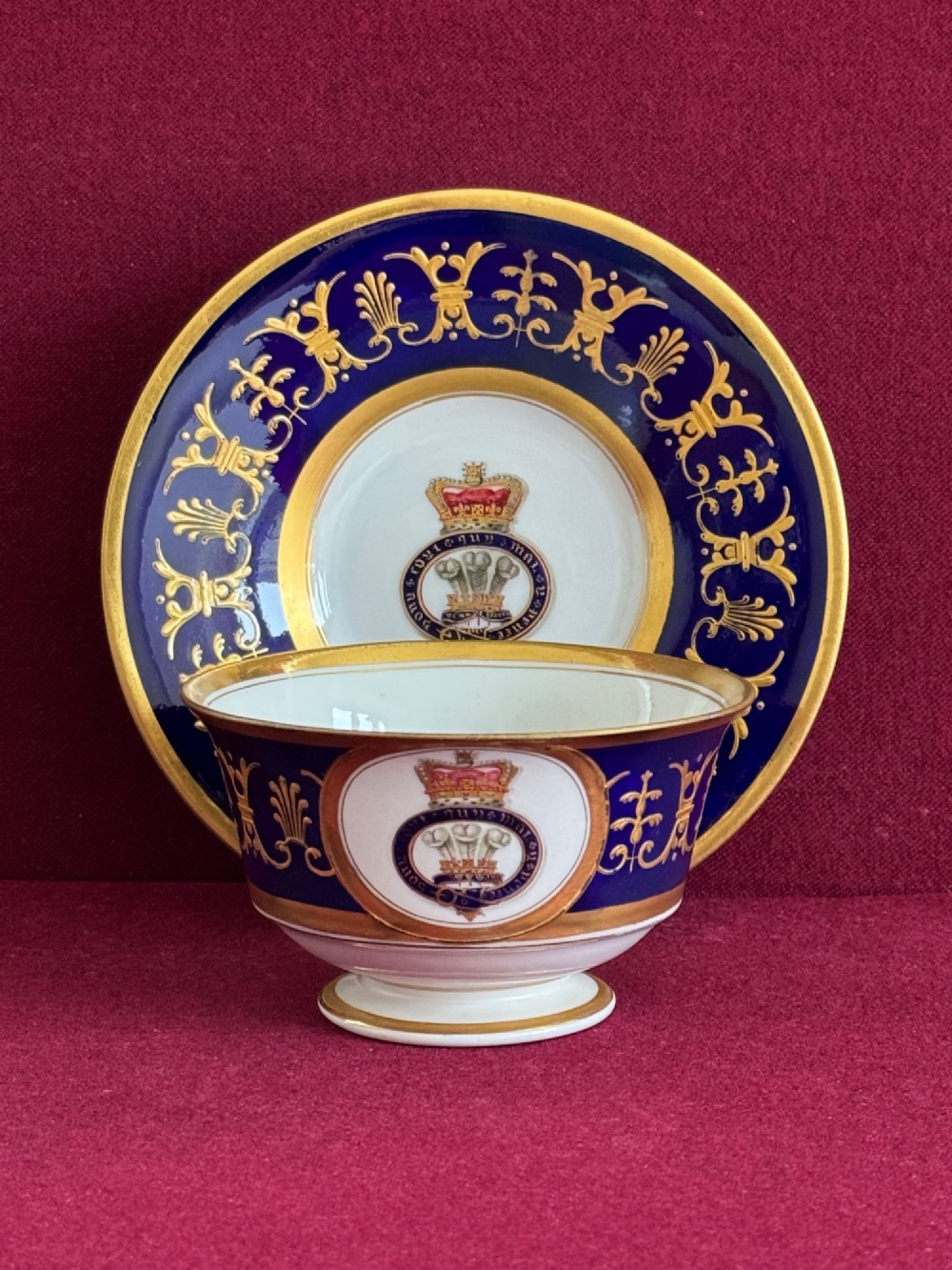 A Regency Flight, Barr and Barr Worcester porcelain cup and saucer featuring a deep cobalt blue border with intricate gold gilding and a central royal armorial crest. View II