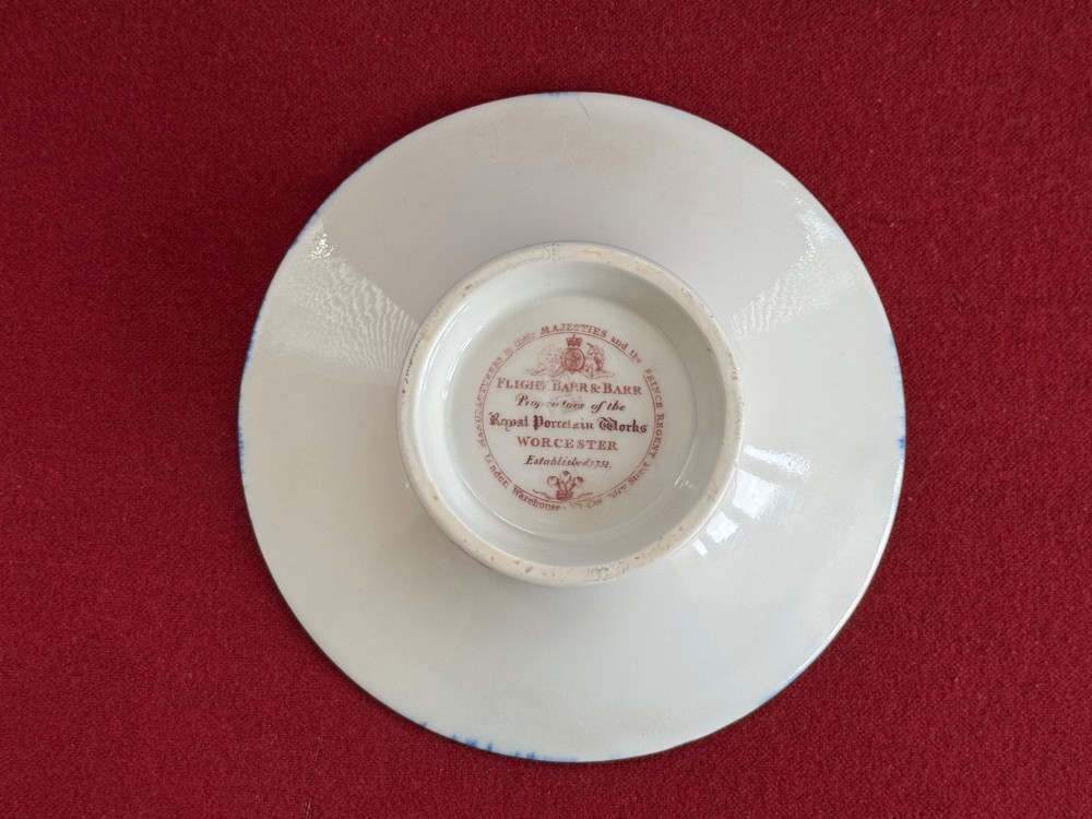 A Regency Flight, Barr and Barr Worcester porcelain cup and saucer featuring a deep cobalt blue border with intricate gold gilding and a central royal armorial crest. View V