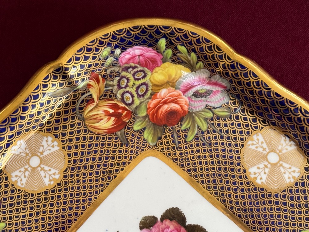 A square Regency porcelain tray featuring hand-painted floral bouquets, an intricate gilt scale pattern over a cobalt blue ground, and a central white reserve with pink roses. View III