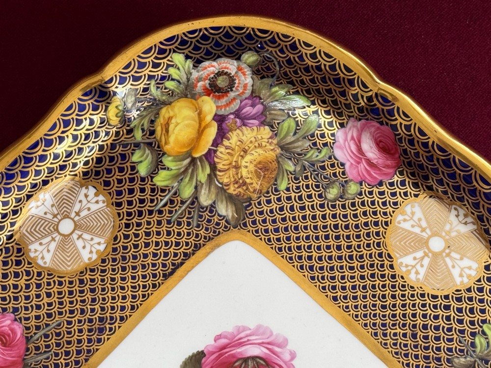 A square Regency porcelain tray featuring hand-painted floral bouquets, an intricate gilt scale pattern over a cobalt blue ground, and a central white reserve with pink roses. View V