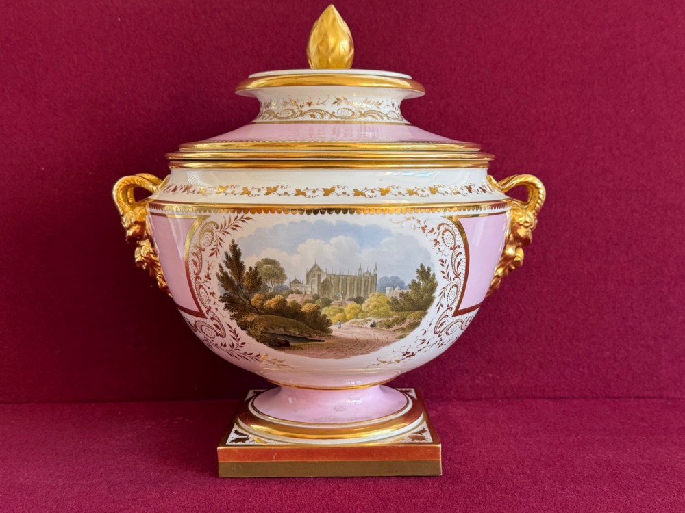 A pair of antique Regency porcelain ice pails featuring pink and white grounds, hand-painted landscape scenes, gilded lion mask handles, and pinecone finials. View IV