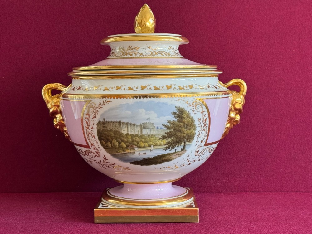 A pair of antique Regency porcelain ice pails featuring pink and white grounds, hand-painted landscape scenes, gilded lion mask handles, and pinecone finials. View VIII