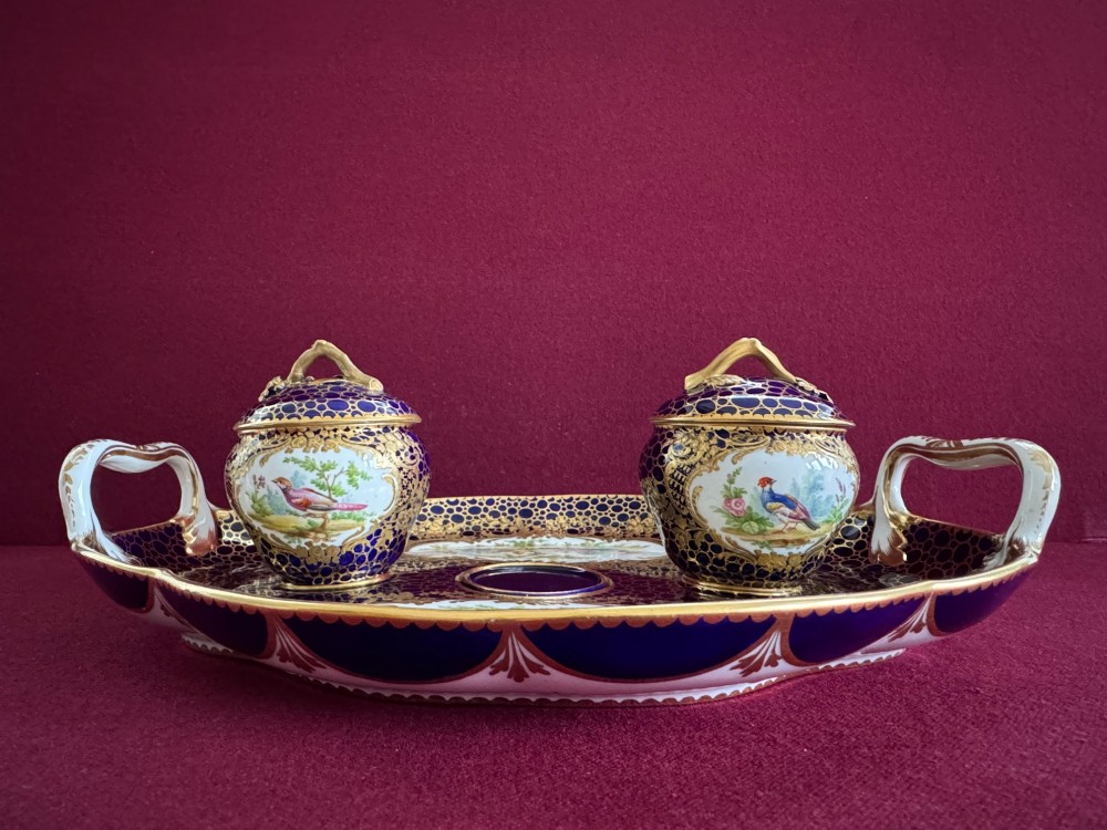 An oval cobalt blue porcelain inkstand decorated with gold honeycomb diapering, hand-painted bird cartouches, and two covered inkwells with gilt branch handles. View III
