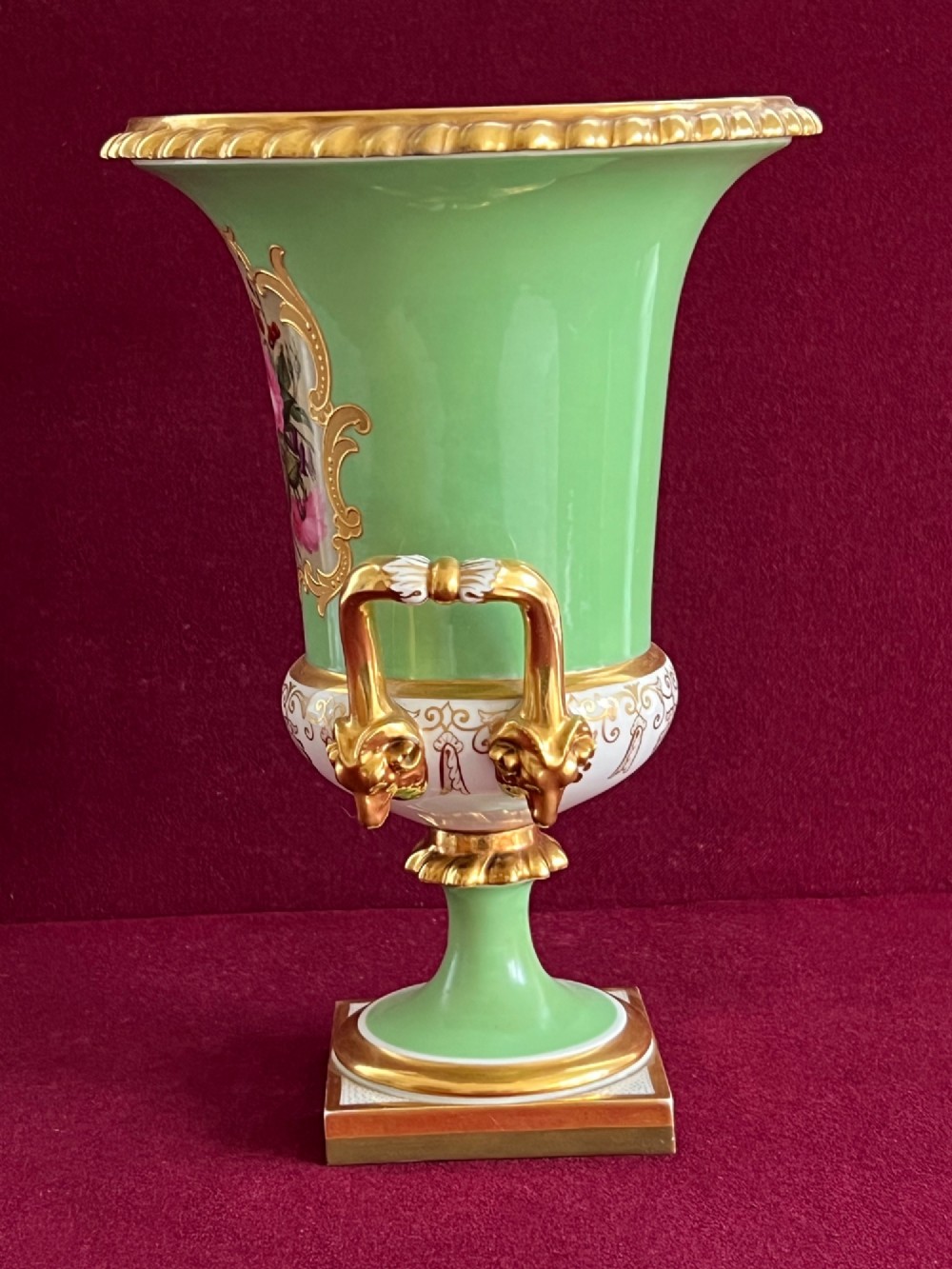 A Flight, Barr & Barr Worcester porcelain Campana shape vase featuring an apple green ground, floral enamel painting, gilt twin handles, and a square base. View III