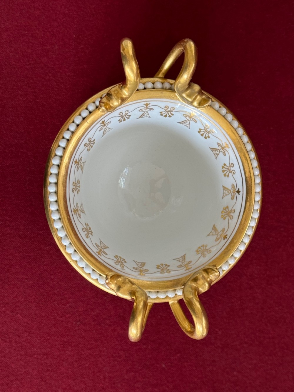 A Regency cobalt blue and gilded porcelain urn featuring a central hand-painted panel of a standing figure in a landscape, twin scroll handles, beaded borders, and a square pedestal base. View VIII