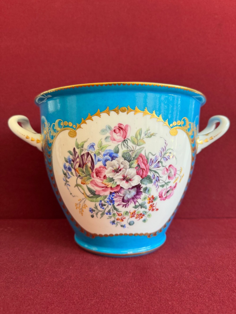 A pair of turquoise porcelain bottle coolers featuring hand-painted fruit cartouches framed by gilded scrollwork and twin handles. View III