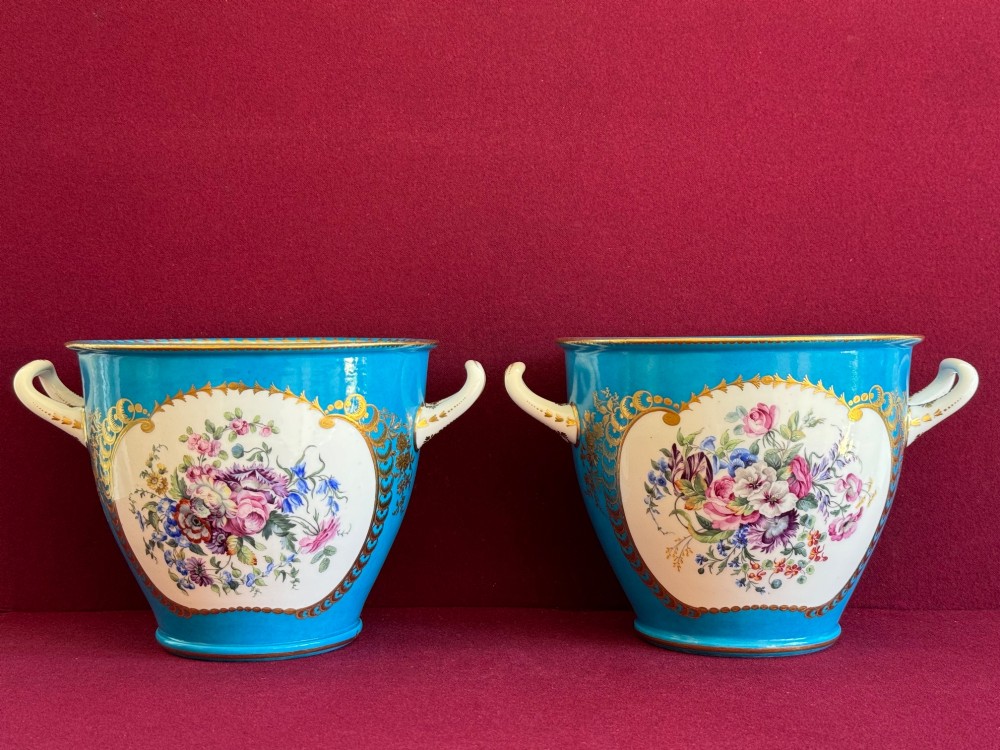 A pair of turquoise porcelain bottle coolers featuring hand-painted fruit cartouches framed by gilded scrollwork and twin handles. View V