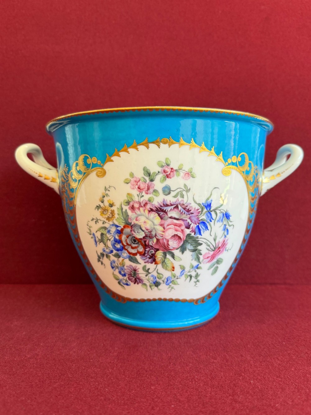 A pair of turquoise porcelain bottle coolers featuring hand-painted fruit cartouches framed by gilded scrollwork and twin handles. View VI