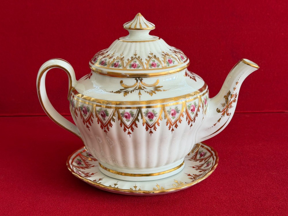 An 18th-century fluted white porcelain teapot and matching oval stand decorated with hand-painted pink floral motifs and gilded geometric borders. View III