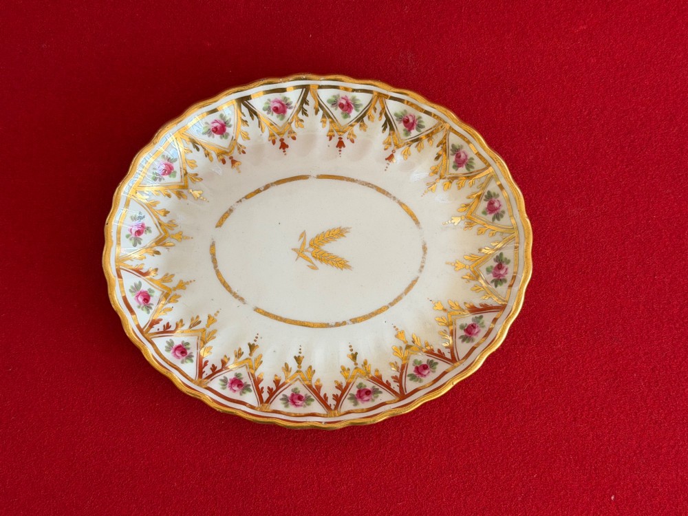 An 18th-century fluted white porcelain teapot and matching oval stand decorated with hand-painted pink floral motifs and gilded geometric borders. View VI