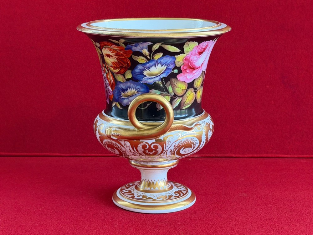 A Regency Derby porcelain campana-shaped urn decorated with hand-painted pink roses on a black ground, featuring gilded handles and neoclassical lower gilding. View IV