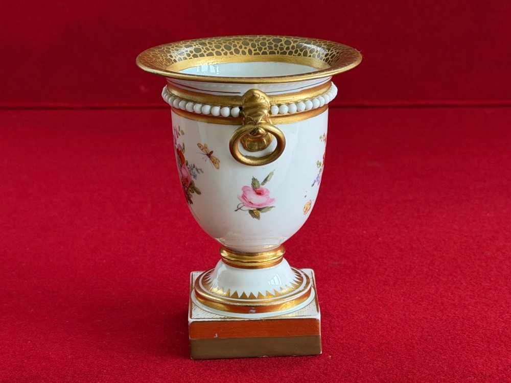 A Regency Flight, Barr and Barr Worcester porcelain campana vase featuring hand-painted floral sprays, gilded handles, a beaded rim, and a square plinth base. View II