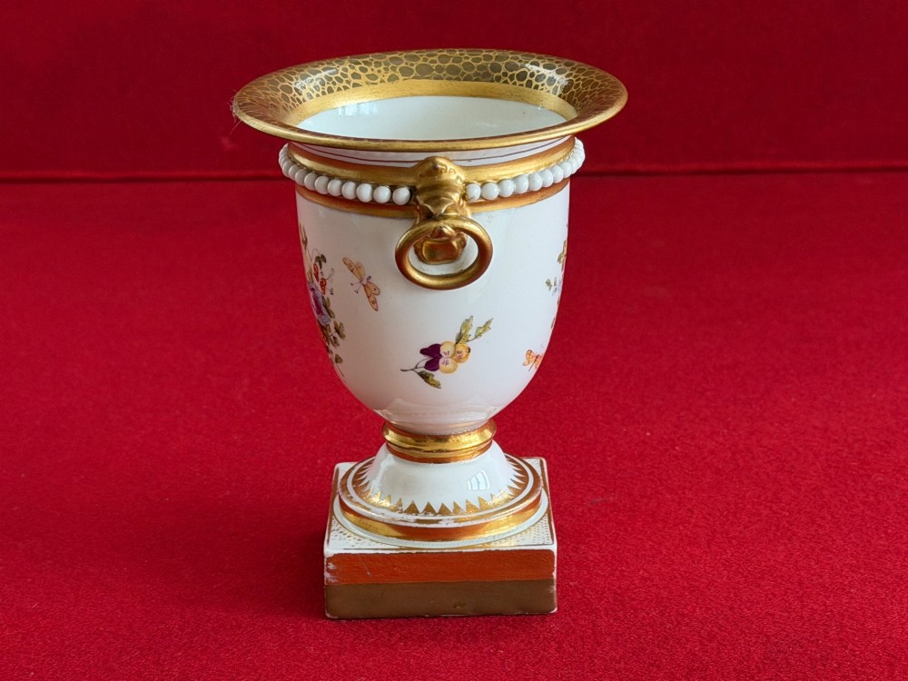 A Regency Flight, Barr and Barr Worcester porcelain campana vase featuring hand-painted floral sprays, gilded handles, a beaded rim, and a square plinth base. View IV