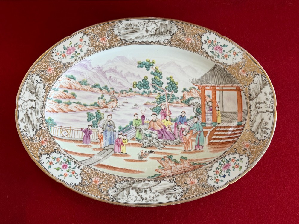 An oval Coalport porcelain meat platter decorated with hand-painted oriental figures in a landscape surrounded by a floral and gilded border.