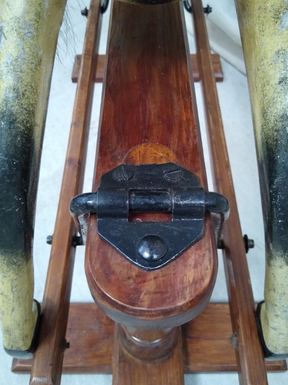 An antique carved wooden rocking horse with a painted dapple finish, leather saddle, and real horsehair mane, mounted on a wooden safety stand. View VII