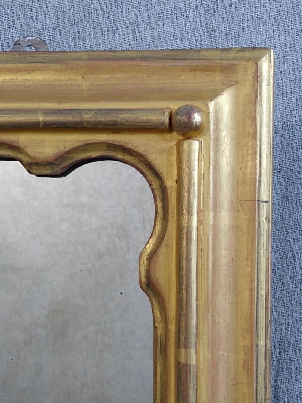 A rectangular Victorian overmantel mirror featuring a gilt frame with side scroll brackets and shaped upper inner corners. View VIII