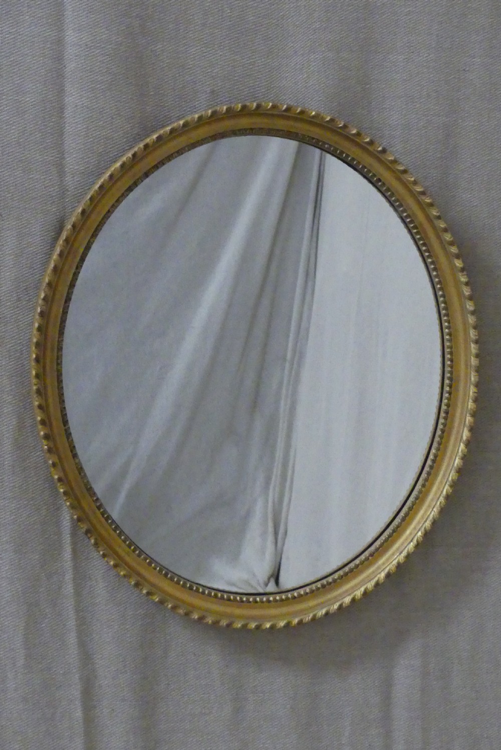 A pair of matching late 19th-century oval mirrors featuring gilded timber frames with beaded edge moulding. View II