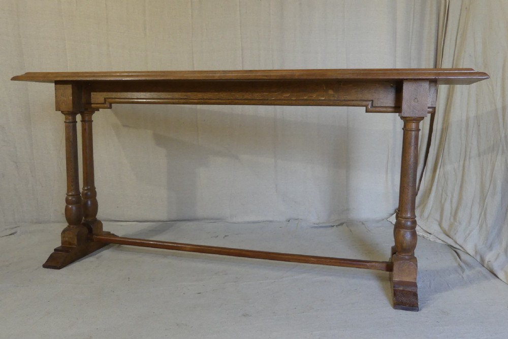 A long, narrow antique oak console table featuring a carved frieze, turned end supports, and a low central stretcher. View VII