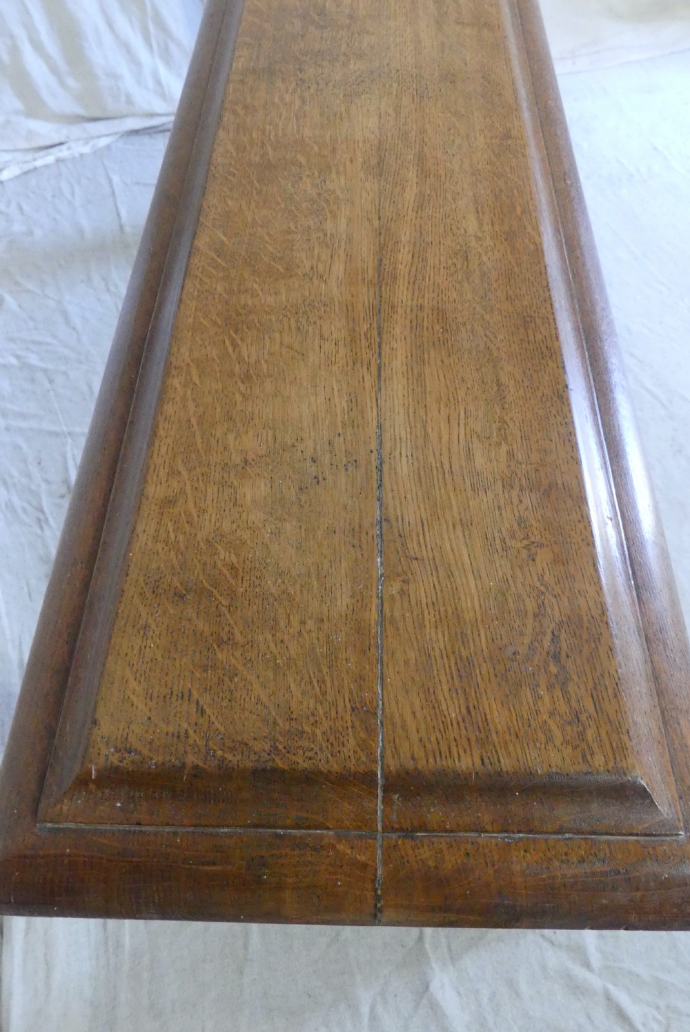 A long, narrow antique oak console table featuring a carved frieze, turned end supports, and a low central stretcher. View XI