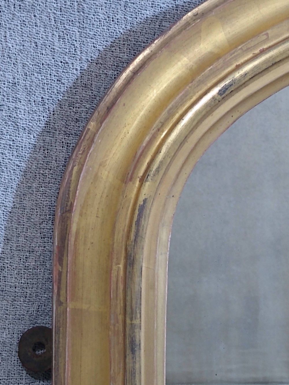 An antique Victorian arched overmantel mirror featuring a gilded frame with acanthus leaf corner details. View II