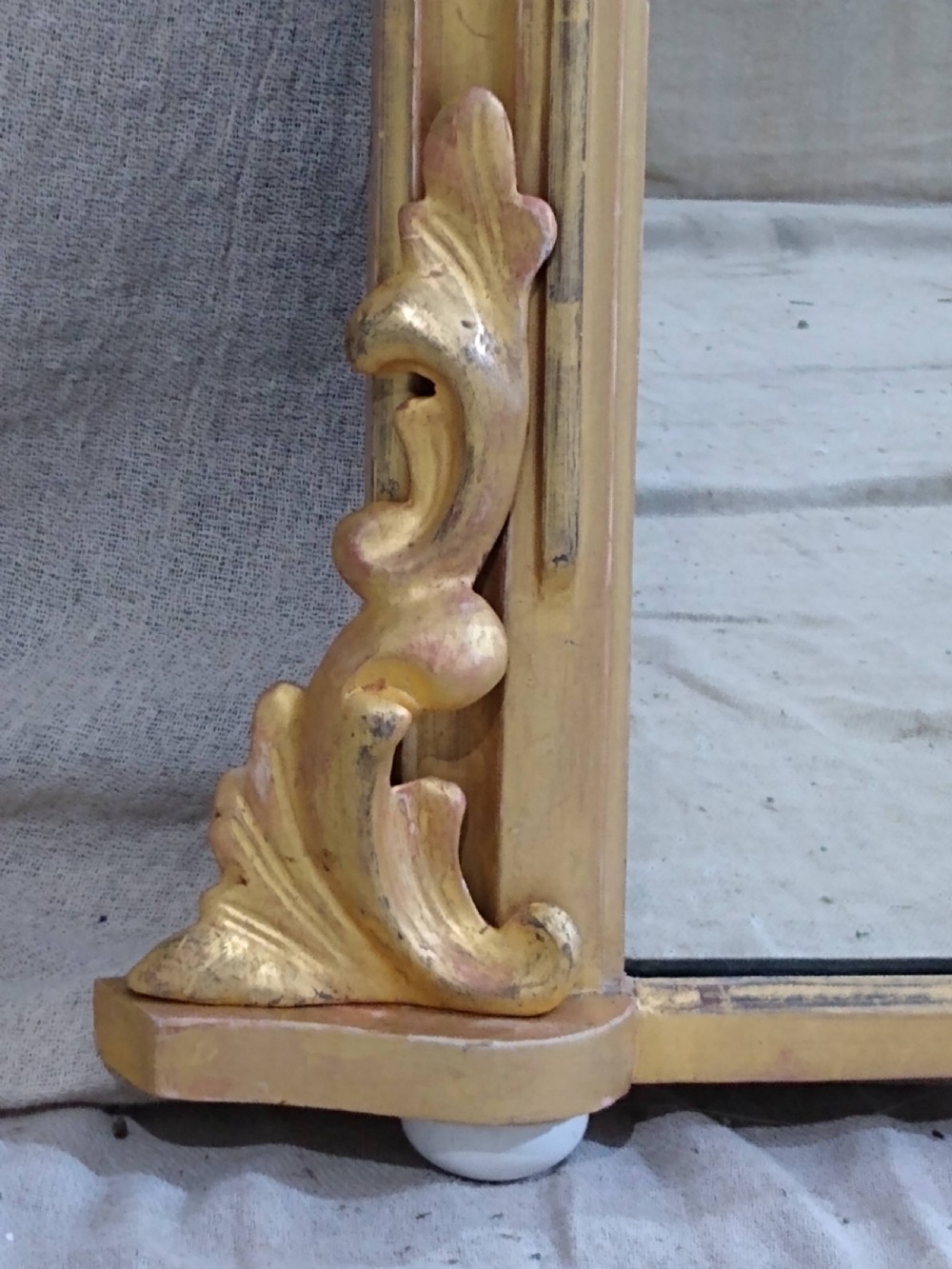 An antique Victorian arched overmantel mirror featuring a gilded frame with acanthus leaf corner details. View III