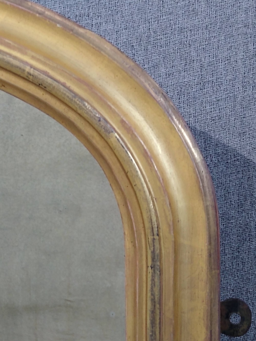 An antique Victorian arched overmantel mirror featuring a gilded frame with acanthus leaf corner details. View VII