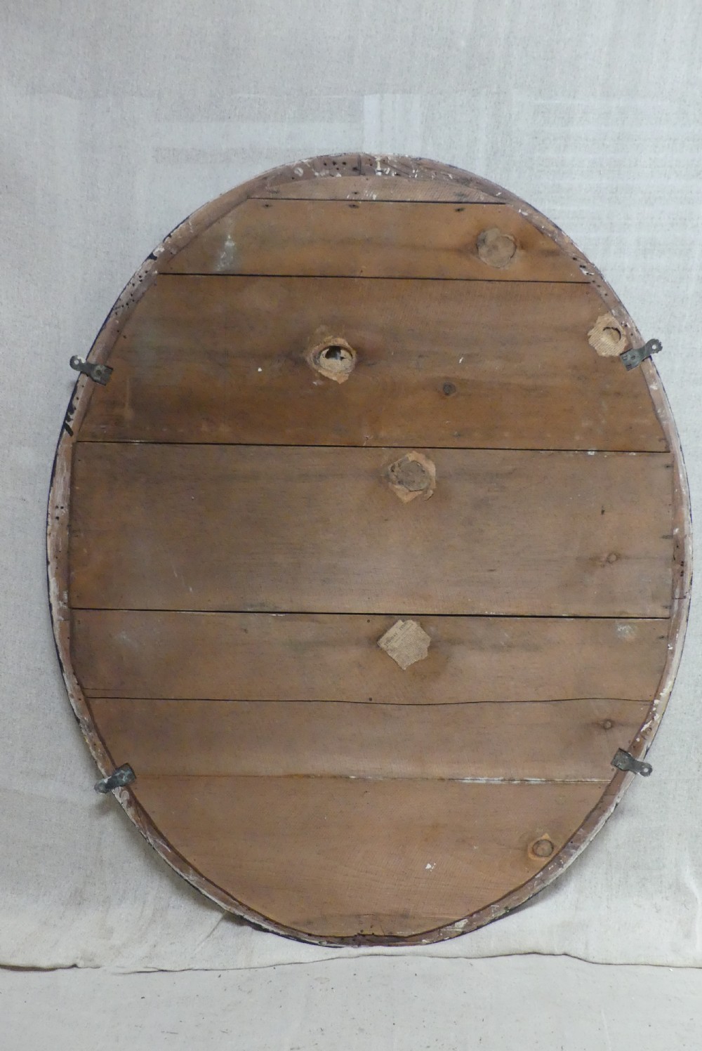 An antique oval wall mirror featuring a black ebonised band inset with round glass studs, framed by an engraved silvered border. View VII