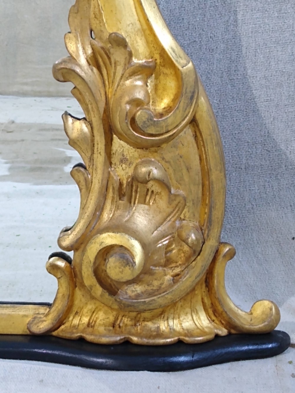 A large Victorian giltwood overmantel mirror featuring an arched top frame moulding and carved acanthus leaf scroll embellishments at the lower base corners. View VI