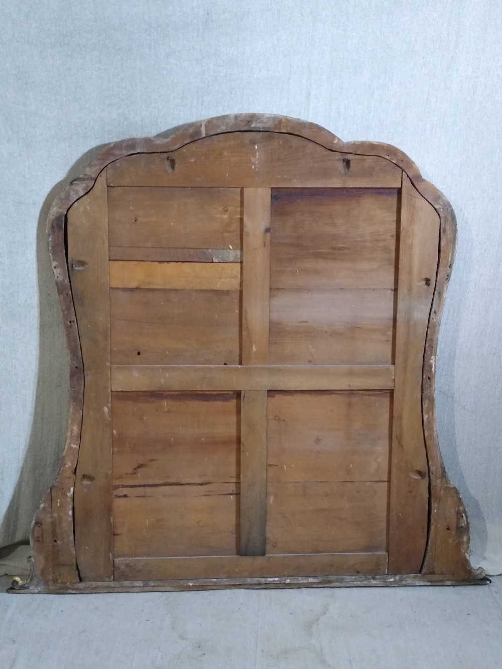 A large Victorian giltwood overmantel mirror featuring an arched top frame moulding and carved acanthus leaf scroll embellishments at the lower base corners. View VII