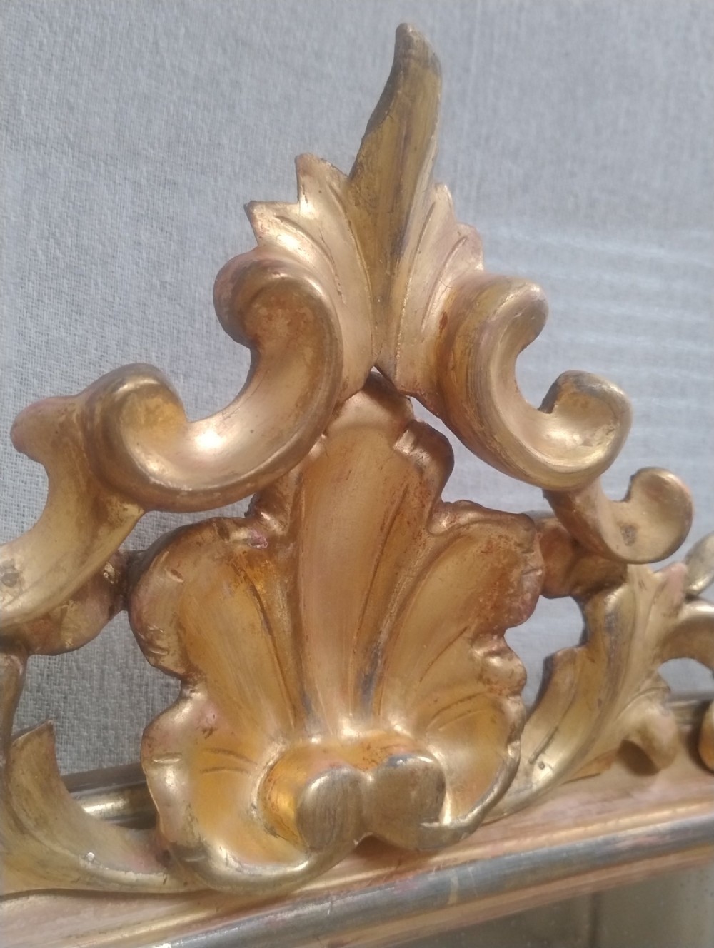 An arched Victorian overmantel mirror with a gilded finish, decorated with a central carved shell crest and scrolled side feet. View VI