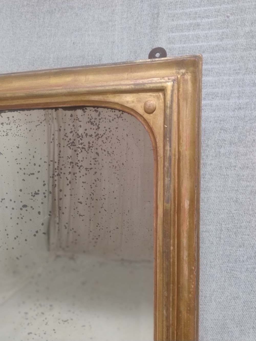 A large rectangular antique gilt overmantel mirror featuring rounded upper corners, moulded frame, and carved acanthus scroll feet at the base. View VII