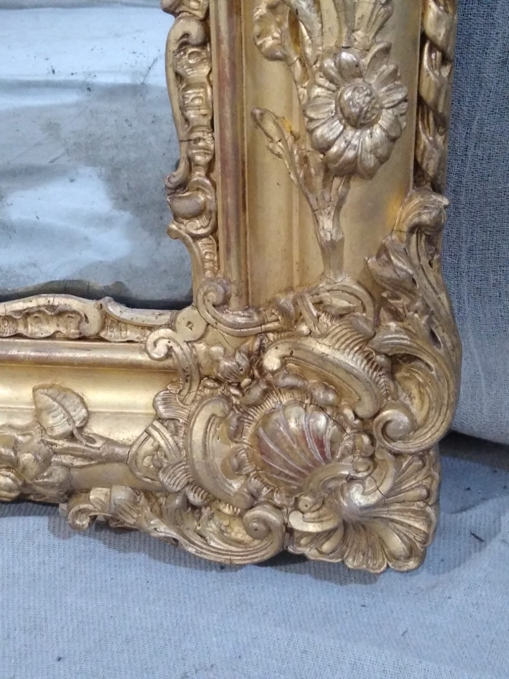 A large rectangular 19th-century French overmantel mirror featuring an ornate gold giltwood frame with detailed foliate and floral moulding. View VI