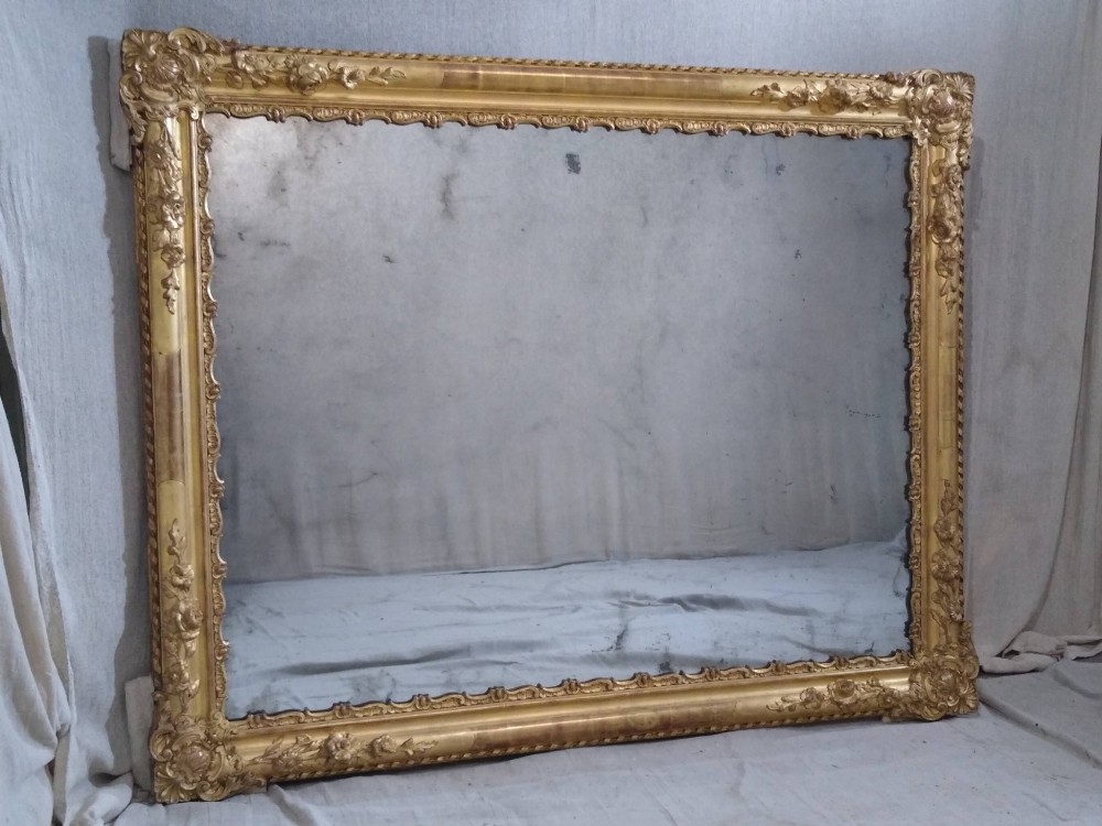 A large rectangular 19th-century French overmantel mirror featuring an ornate gold giltwood frame with detailed foliate and floral moulding. View VII